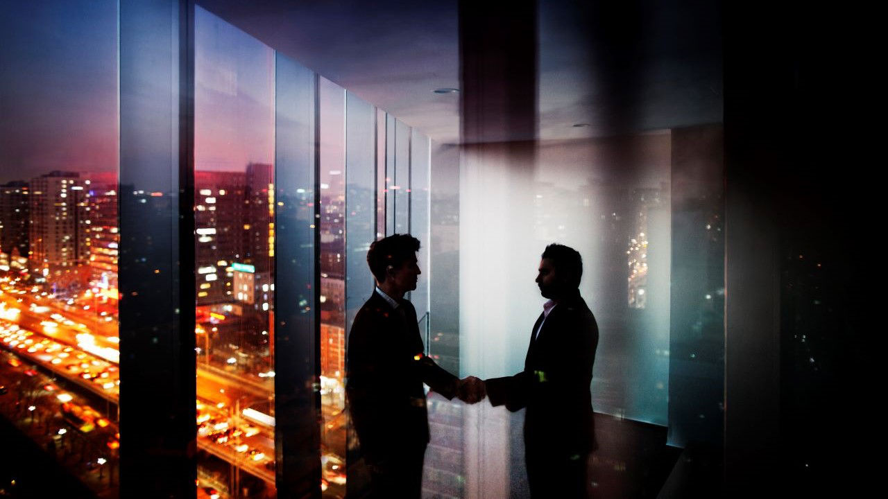 businessmen-shaking-hands-at-night