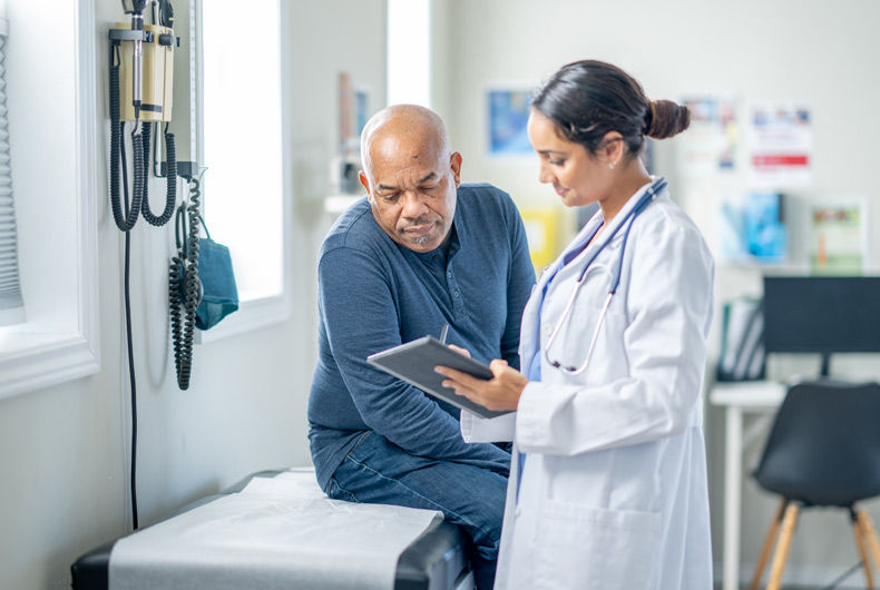 Doctor reviewing information on a tablet with a patient during a medical consultation