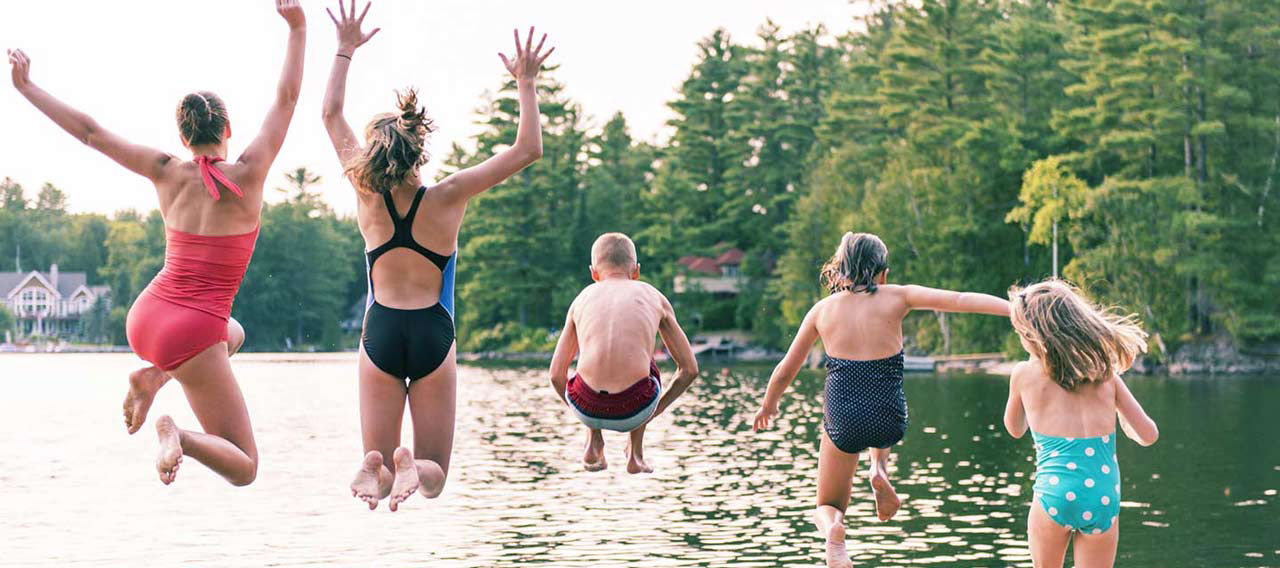 family jumping into lake