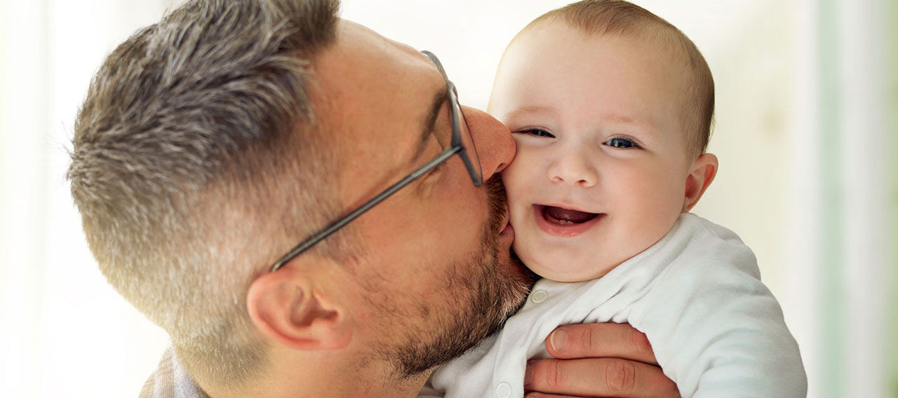 father kissing his baby