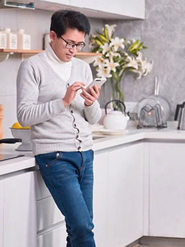 man texting in kitchen