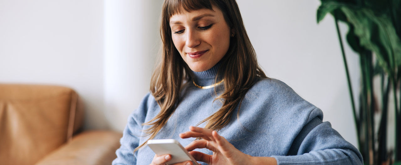 woman using her phone, smiling
