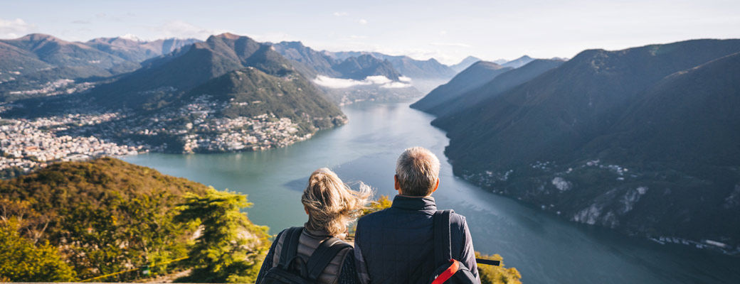 Two travelers pausing to take in a scenic mountain view