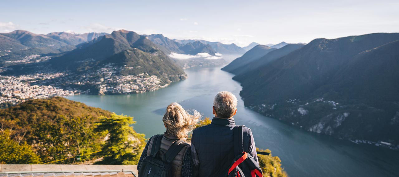 Two travelers pausing to take in a scenic mountain view