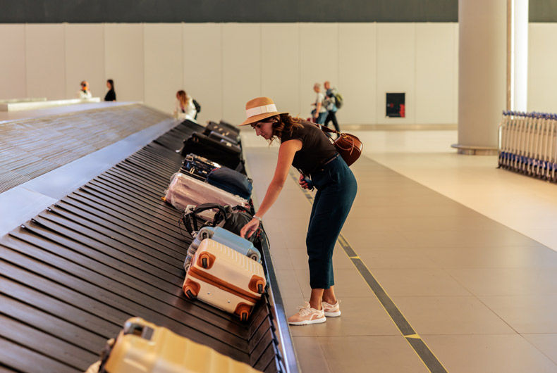 Woman retrieving luggage from an airport baggage carousel