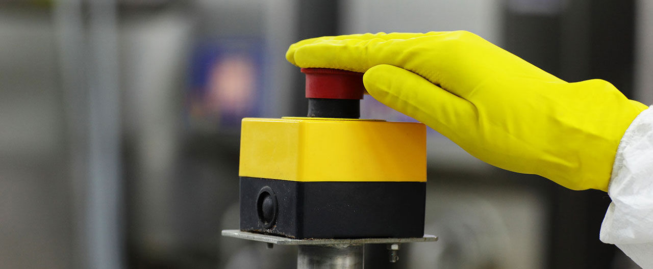 yellow gloved hand on button